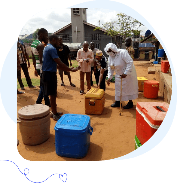 People collecting water outdoors with containers in a community setting.