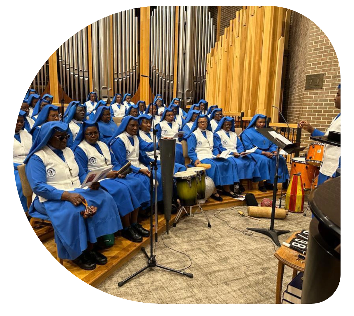 A choir dressed in blue robes singing in a church.