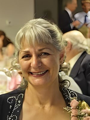 Smiling woman with gray hair at a social event.