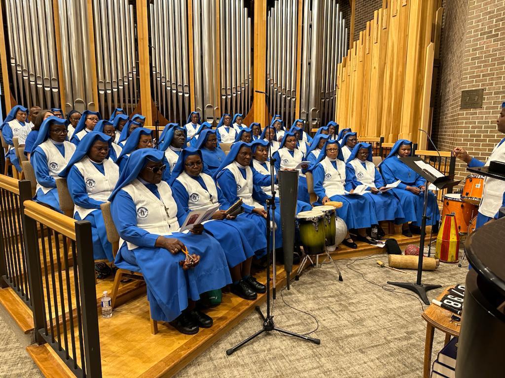 A choir dressed in blue robes singing in a church.
