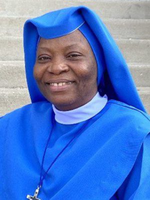 Smiling woman dressed in a blue religious habit.