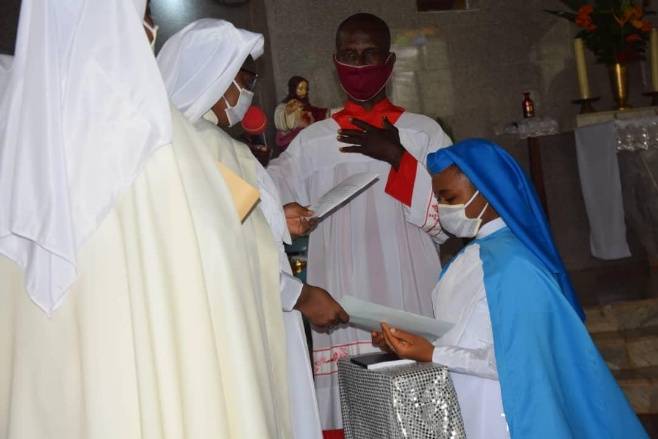 A religious ceremony with nuns and altar servers in traditional attire.