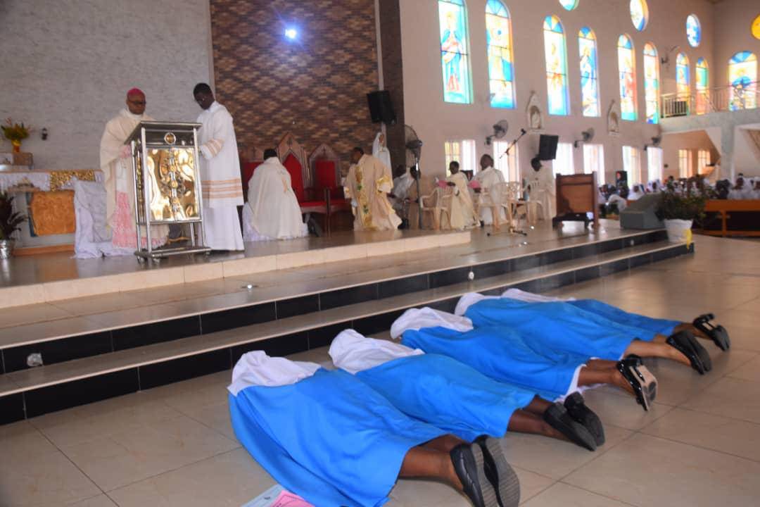 Nuns lying prostrate during a religious ceremony inside a church.