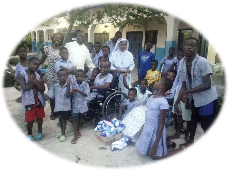 Group of children and adults, some in school uniforms, gathered outdoors near a building.