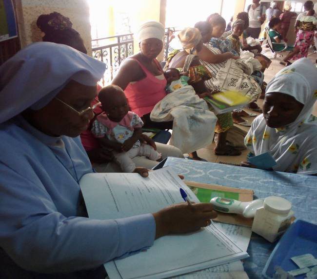 Healthcare workers attend to patients in a busy clinic setting.