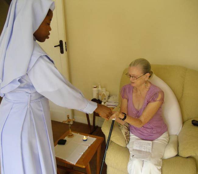 Nurse checking an elderly woman's blood pressure in a cozy room.