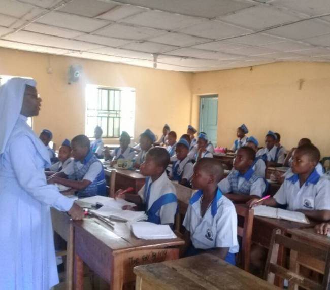 A nurse educating schoolchildren in a classroom setting.
