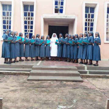 A group of nuns standing in front of a building.