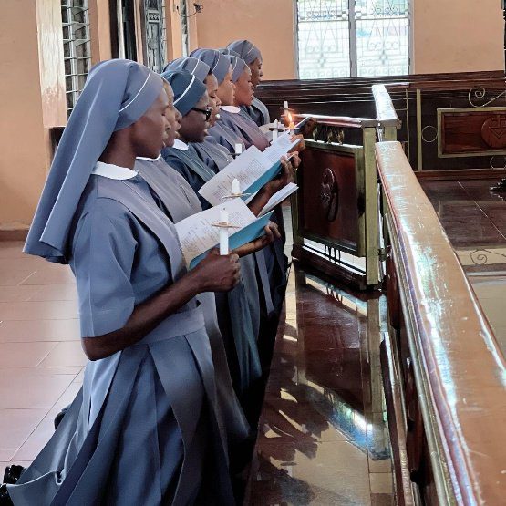 Nuns singing hymns in a church pew.