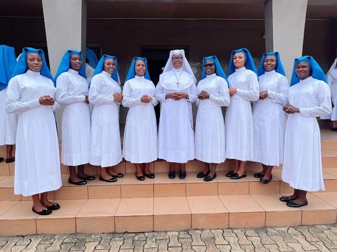 A group of nuns standing together outside a building.