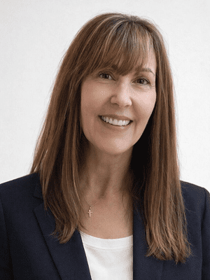 Professional woman with long brown hair smiling in business attire.
