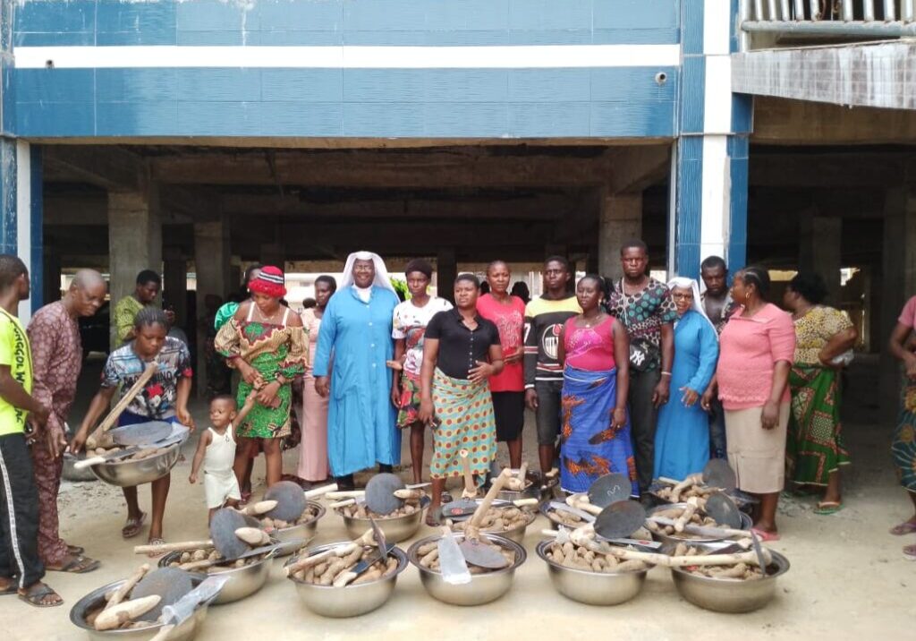 A group of women standing behind handmade clay pots outdoors.